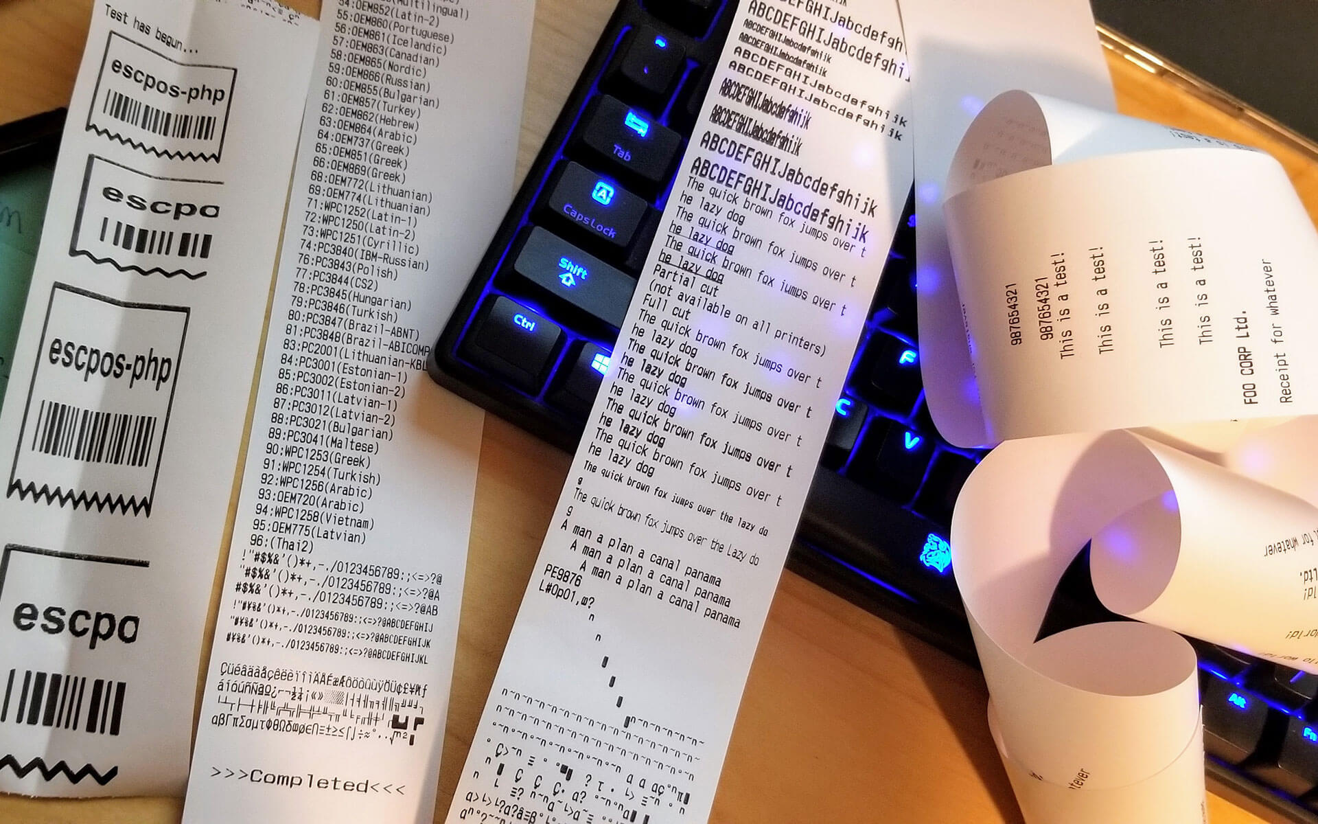 Test printouts on receipt paper strewn on a desk